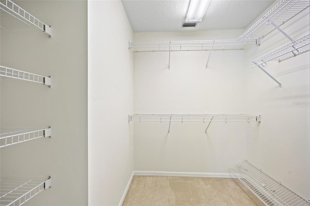 walk in closet featuring carpet flooring and visible vents