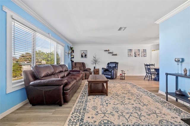 living room featuring visible vents, wood finished floors, and ornamental molding