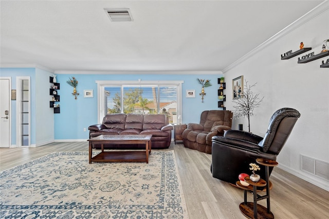 living area with visible vents, crown molding, and light wood finished floors