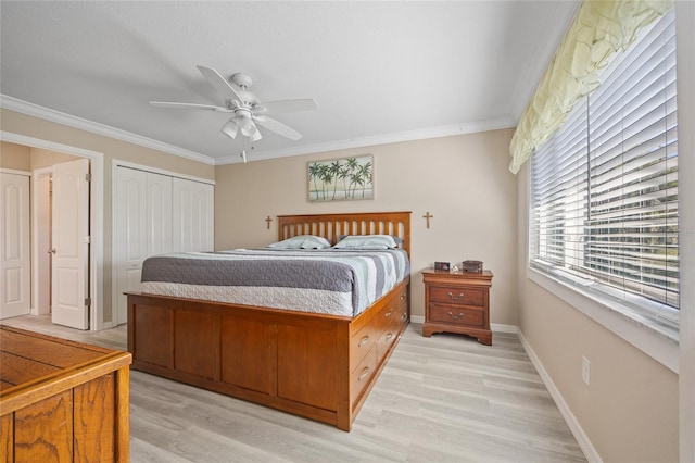 bedroom featuring light wood-type flooring, ornamental molding, a closet, baseboards, and ceiling fan