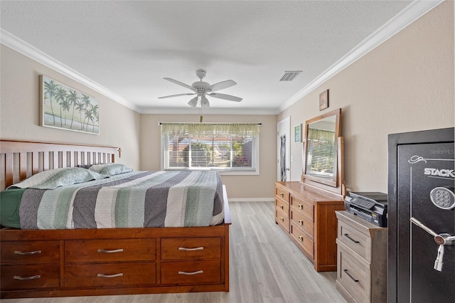 bedroom with visible vents, a textured ceiling, light wood-type flooring, and ornamental molding