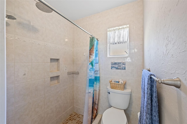 full bathroom featuring toilet, a textured wall, and a tile shower