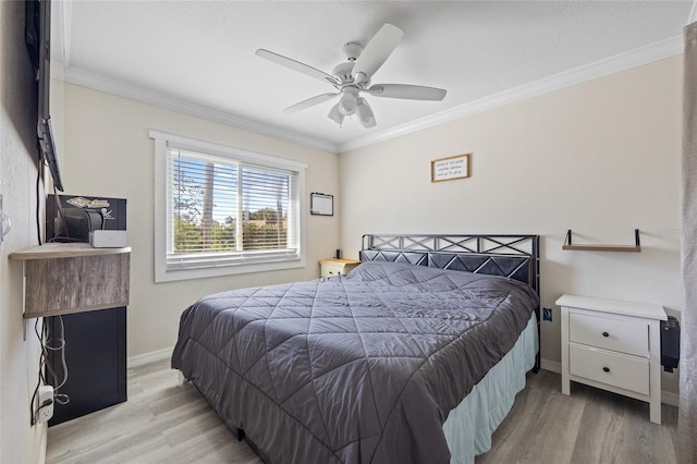 bedroom with crown molding, light wood-style flooring, and baseboards