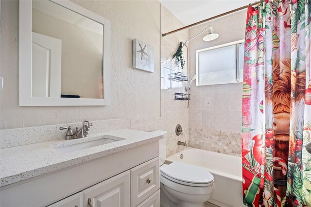 full bath with vanity, toilet, shower / bathtub combination with curtain, and a textured wall