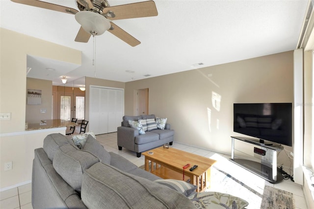 living area with a ceiling fan, visible vents, and light tile patterned floors