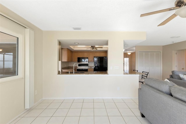interior space featuring light tile patterned floors, visible vents, baseboards, ceiling fan, and a tray ceiling