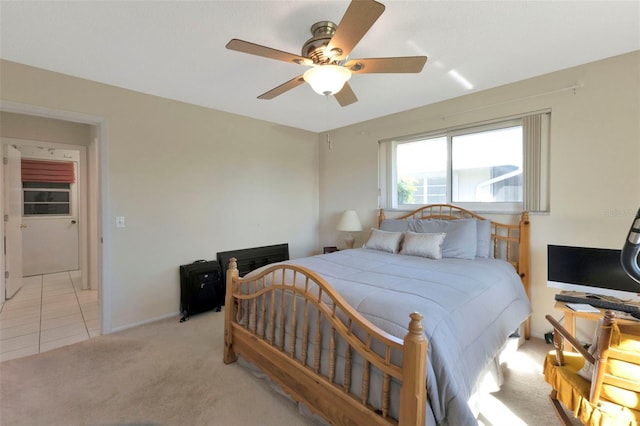 bedroom featuring light carpet, light tile patterned floors, and a ceiling fan