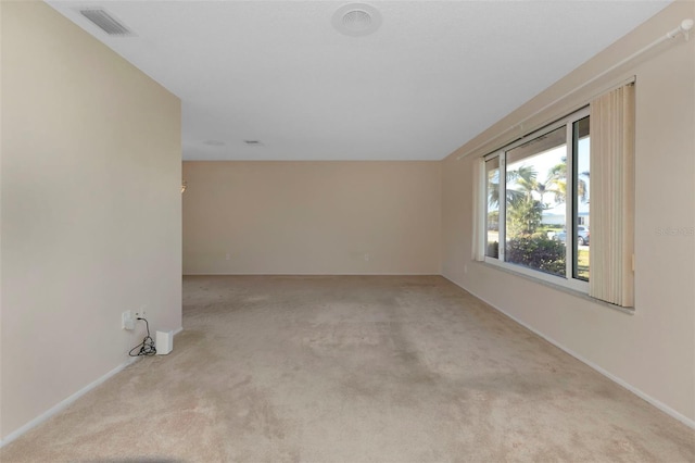 unfurnished room with carpet, visible vents, and baseboards