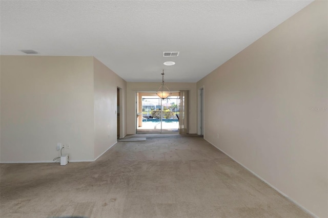 hallway featuring light colored carpet, visible vents, a textured ceiling, and baseboards
