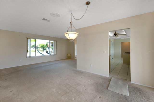 tiled empty room with baseboards, visible vents, and carpet flooring