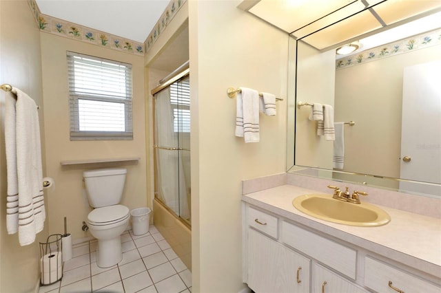 bathroom with vanity, combined bath / shower with glass door, tile patterned flooring, and toilet