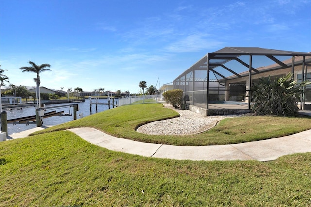 view of yard featuring a boat dock, a water view, boat lift, and a lanai