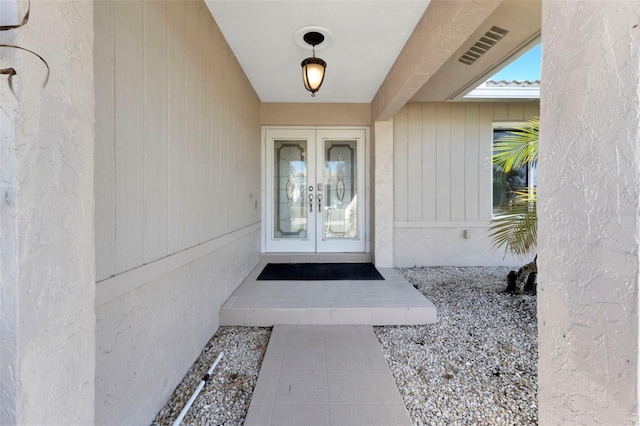 view of exterior entry with french doors and visible vents