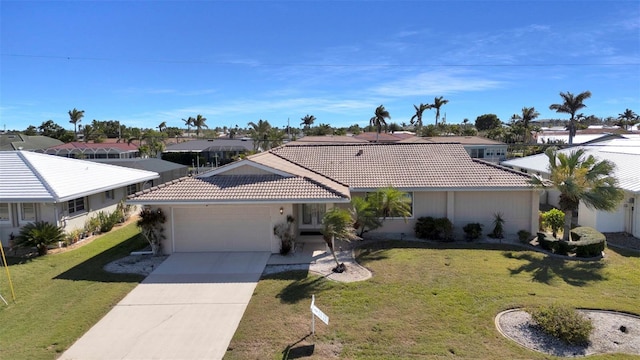 view of front of house featuring a front yard, a tile roof, driveway, and a residential view