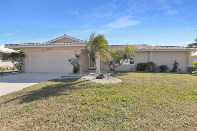 ranch-style house with an attached garage, a tile roof, concrete driveway, stucco siding, and a front lawn