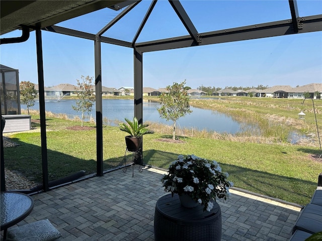 unfurnished sunroom with plenty of natural light, a water view, and a residential view