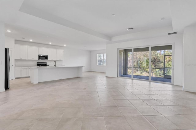 unfurnished living room featuring recessed lighting, visible vents, a sink, and light tile patterned flooring