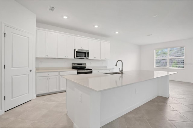 kitchen featuring a center island with sink, light countertops, visible vents, appliances with stainless steel finishes, and a sink