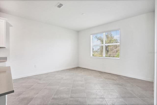 spare room featuring visible vents and baseboards