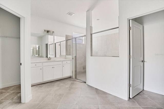 full bath with visible vents, a shower stall, vanity, baseboards, and tile patterned floors