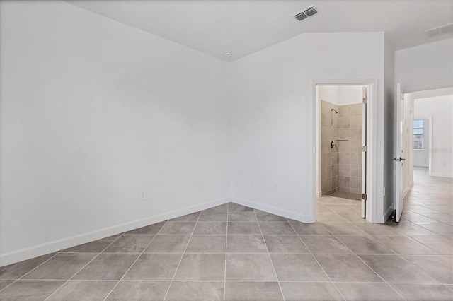 tiled spare room featuring visible vents and baseboards