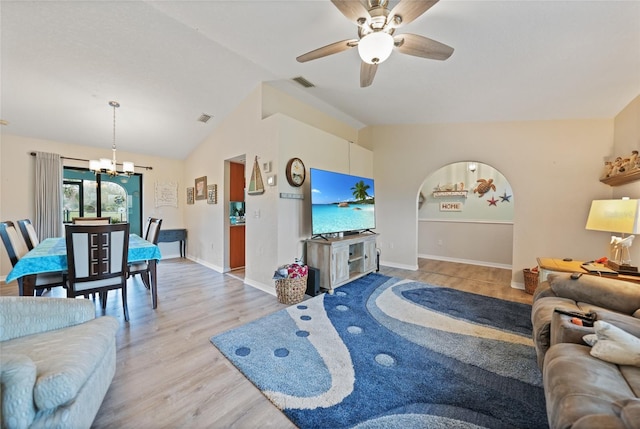 living area with lofted ceiling, visible vents, wood finished floors, baseboards, and ceiling fan with notable chandelier