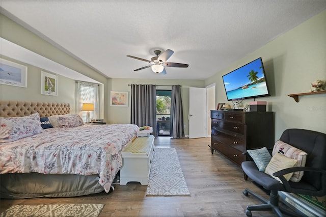 bedroom with a ceiling fan, multiple windows, a textured ceiling, and wood finished floors