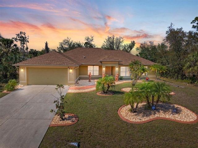 view of front of property with concrete driveway, a yard, an attached garage, and stucco siding