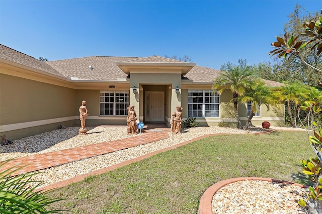 exterior space with roof with shingles, a lawn, and stucco siding