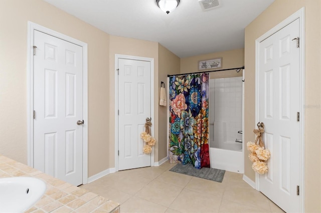 bathroom featuring visible vents, shower / tub combo with curtain, baseboards, and tile patterned floors