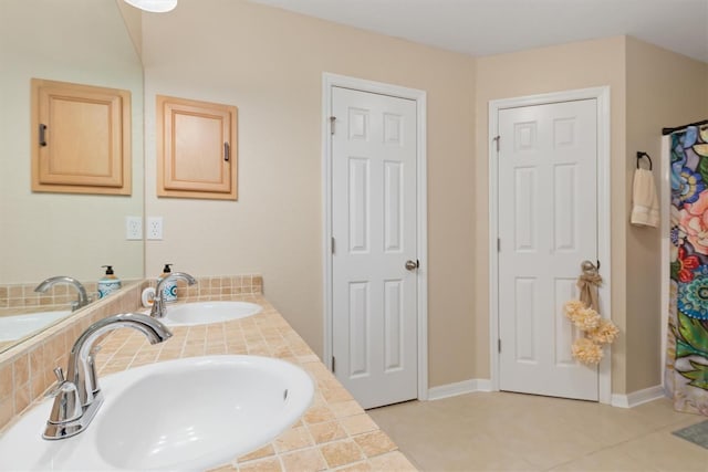 full bathroom featuring double vanity, tile patterned flooring, and a sink