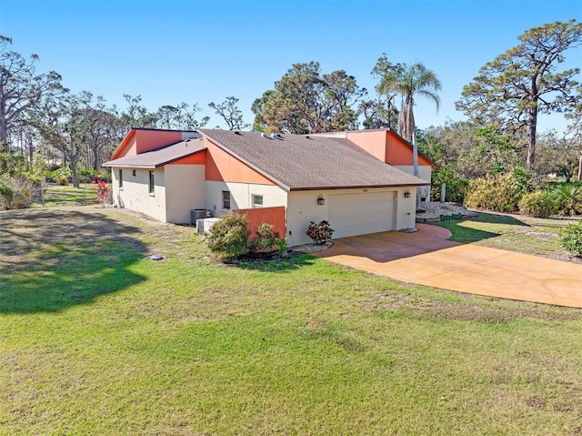 view of side of home with a yard, driveway, an attached garage, and stucco siding