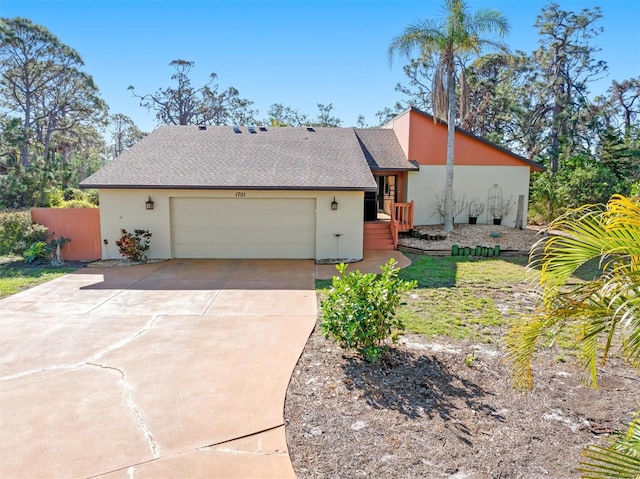 mid-century modern home featuring driveway, an attached garage, roof with shingles, and stucco siding