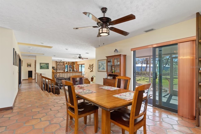 dining space with a textured ceiling, french doors, a wealth of natural light, and visible vents