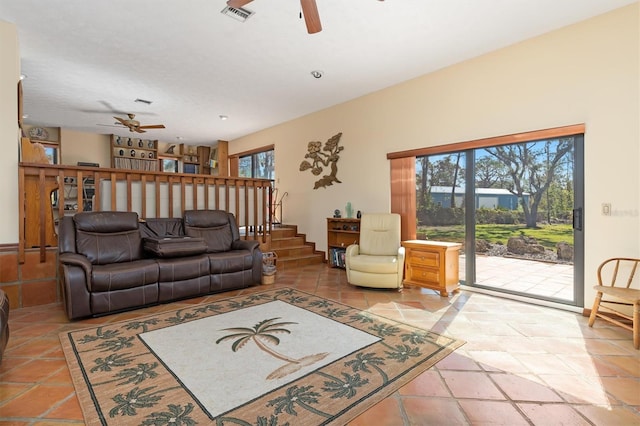 living room with ceiling fan, stairs, and visible vents