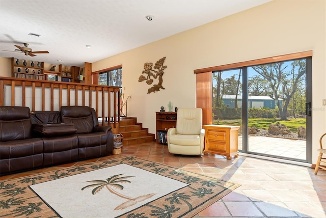 living area with stairway and a ceiling fan