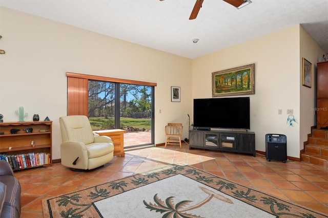 tiled living area featuring ceiling fan, stairway, and baseboards