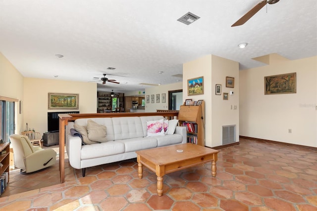 living area with a ceiling fan, visible vents, a textured ceiling, and baseboards