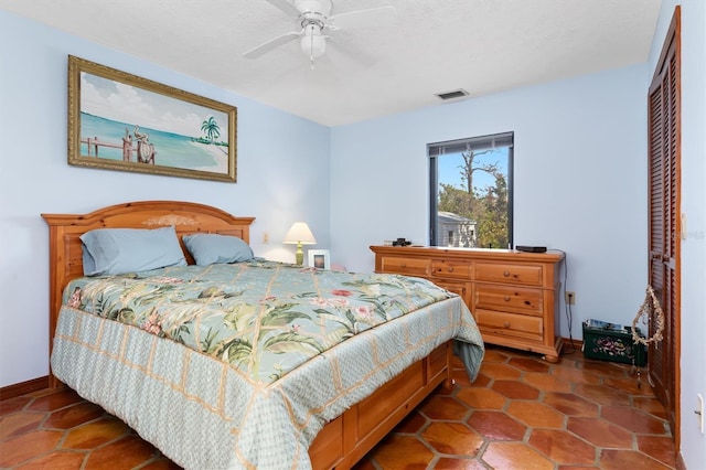 bedroom with a ceiling fan, a closet, visible vents, and baseboards