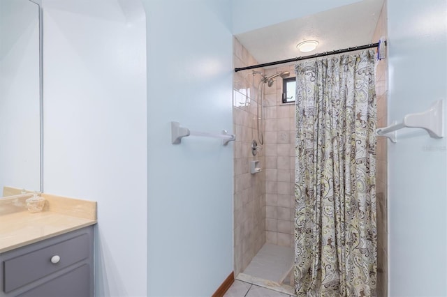 bathroom featuring tiled shower and vanity