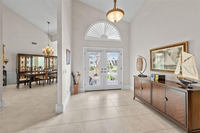 foyer entrance with french doors, light tile patterned floors, visible vents, a chandelier, and baseboards