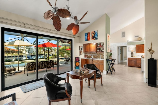 living area featuring high vaulted ceiling, a sunroom, a ceiling fan, visible vents, and wet bar