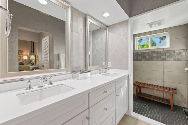 full bathroom with ensuite bathroom, double vanity, a sink, and tile patterned floors