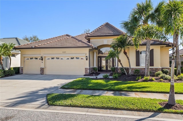 view of front of property featuring a garage, stone siding, french doors, and stucco siding