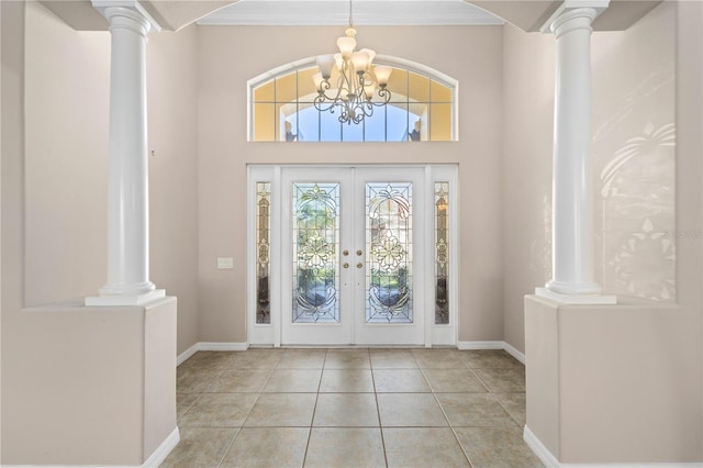 foyer featuring tile patterned flooring, french doors, and decorative columns