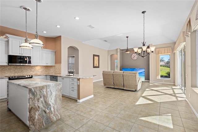 kitchen featuring a peninsula, a sink, visible vents, appliances with stainless steel finishes, and tasteful backsplash