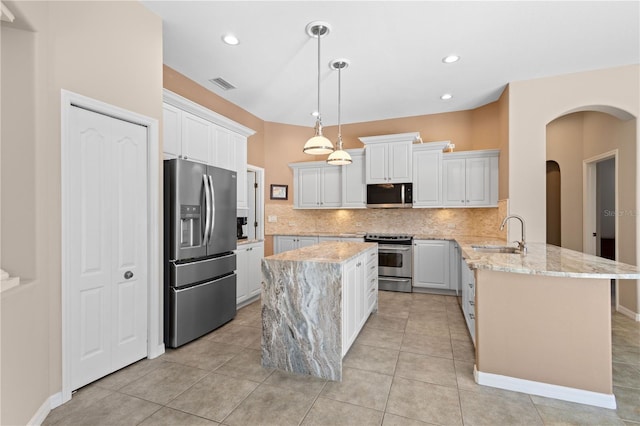 kitchen featuring arched walkways, visible vents, appliances with stainless steel finishes, a sink, and a peninsula