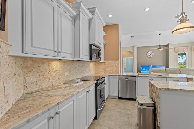 kitchen featuring light tile patterned floors, a sink, white cabinetry, appliances with stainless steel finishes, and tasteful backsplash