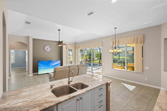 kitchen with light stone countertops, visible vents, a sink, and light tile patterned flooring