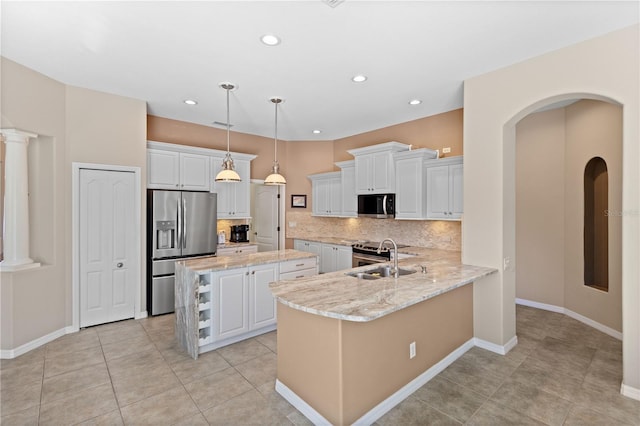 kitchen featuring white cabinets, a kitchen island, a sink, stainless steel appliances, and backsplash